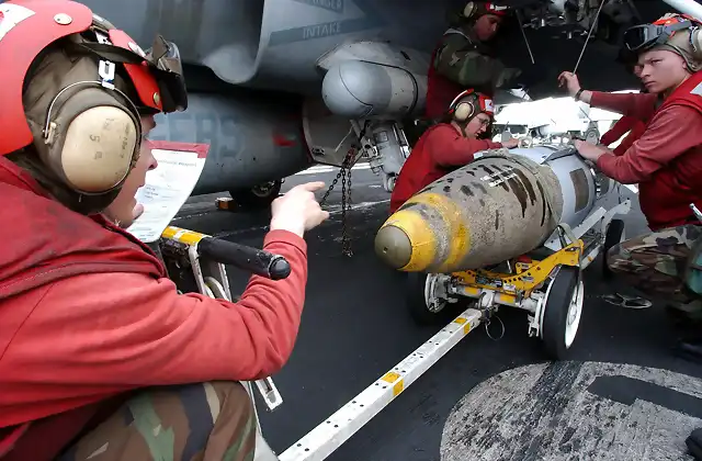 US_Navy_030321-N-3235P-513_Aviation_Ordnancemen_rig_support_suspension_equipment_to_load_a_2000_lbs_GBU-31_Joint_Direct_Attack_Munitions_(JDAM)_onto_the_wing_of_an_F-A-18_Hornet_on_the_flight_deck_aboard_the_aircraft_carrier_US