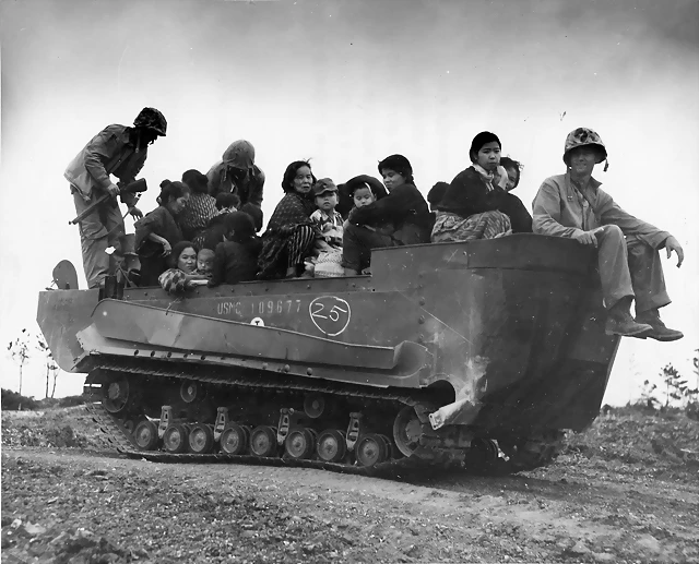 Nativos de Kiniawa tramnsportados por un vehículo anfibio de los Marines Nativos de Kiniawa tramnsportados por un vehículo anfibio de los Marines