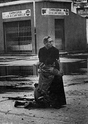 1962 Un soldado herido por un francotirador se abraza al capelln de la armada Luis Padillo en la base naval venezolana de Puerto Capello.