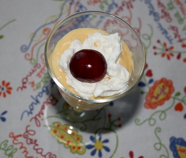 Postre de crema, nata y cereza