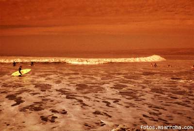 Un atardecer captado en el sector de La Puntilla, con surfistas al trasluz.