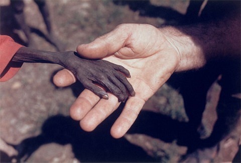 1980 Un misionero agarra la mano de un nio a punto de morir de hambre en Karamoja, Uganda.