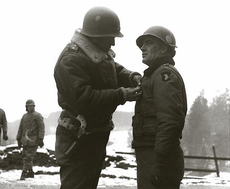 Patton condecora al General Anthony McAuliffe con la Cruz de Méritos Distinguidos por la defensa de Bastogne Patton condecora al General Anthony McAuliffe con la Cruz de Méritos Distinguidos por la defensa de Bastogne