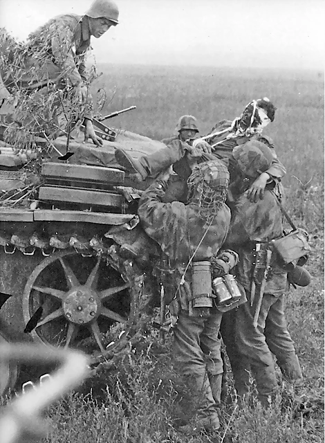 Soldados Waffen SS cargan a un compaerp herido en un Panzer III, cerca de Belogorod, 1 agosto de 1943