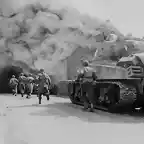 Miembros del 55 Batalln de Infanteria y un tanque del 22 Batalln entrando en una calle en llamas en Wernberg. Alemania. 1945