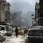 A-man-walks-by-destroyed-vehicles-in-a-street-in-the-Old-City-of-Mosul-on-July-2-2017.-AFP