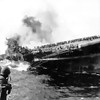 March 19, 1945 The USS Santa Fe lies alongside the heavily listing USS Franklin to provide assistance after the aircraft carrier had been hit and set afire by a single Japanese dive bomber, during the Okinawa