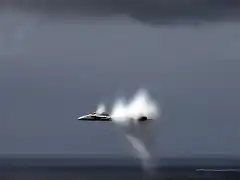 FA-18 Hornet rompiendo la barrera del sonido cerca de la superficie del mar