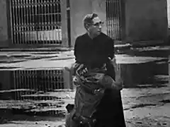 1962 Un soldado herido por un francotirador se abraza al capelln de la armada Luis Padillo en la base naval venezolana de Puerto Capello.