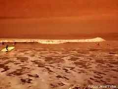 Un atardecer captado en el sector de La Puntilla, con surfistas al trasluz.