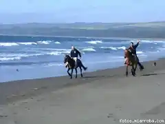 Una pareja de gringos disfrutan de una cabalgata a la orilkla de la Playa San Antonio, de Pichilemu.