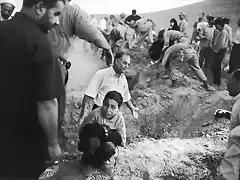 2002 Rodeado de gente y soldados que caban fosas para las vctimas de un terremoto, un nio sujeta los pantalones de su padre muerto